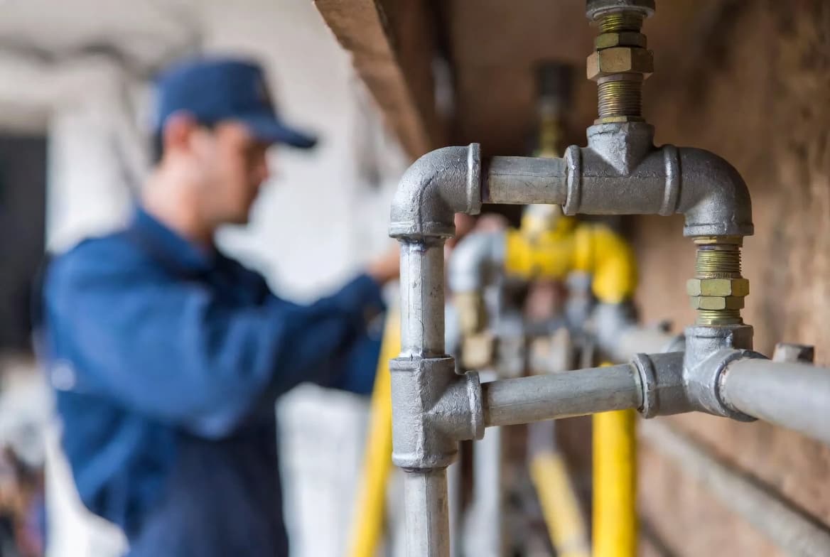 Gasista matriculado revisando instalación de gas con detector de fugas en cocina de Buenos Aires